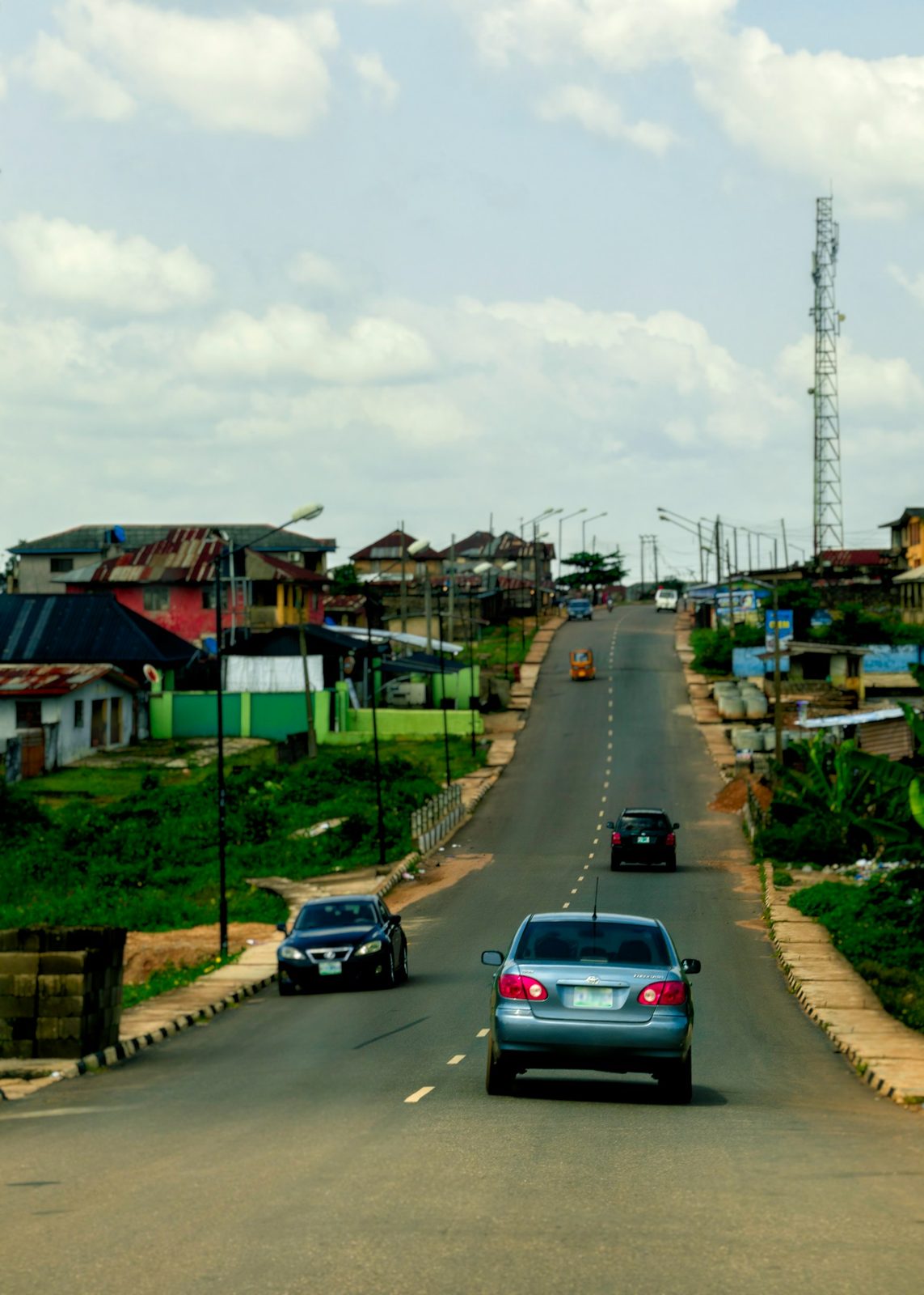 Car on a green hillside road in Nigeria